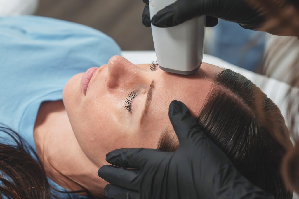 Patient smiling during a facial skincare treatment.
